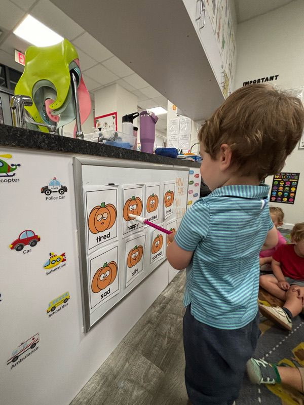 A child exploring a classroom activity board