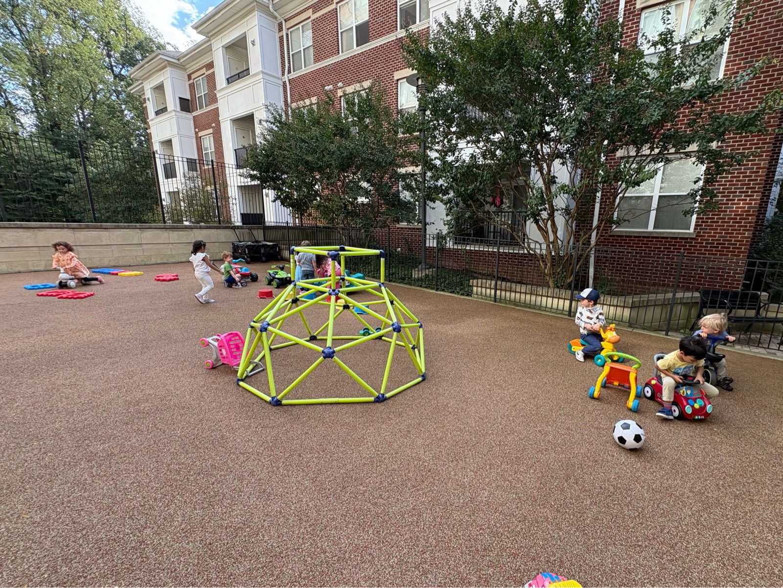 A wide view of children playing in the outdoor courtyard